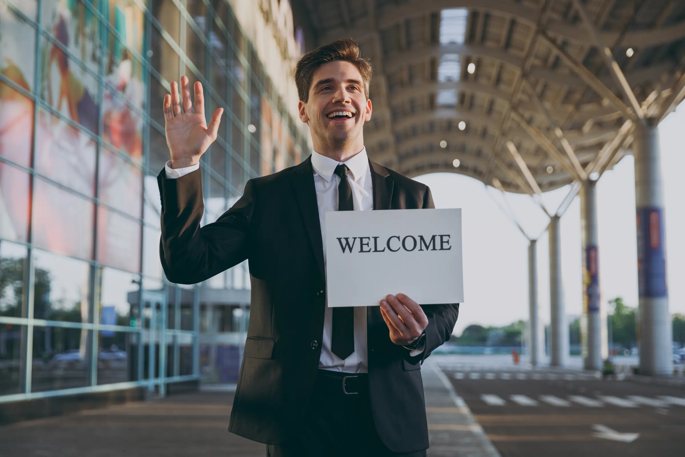 Airport greeter holding a welcome sign outside the terminal