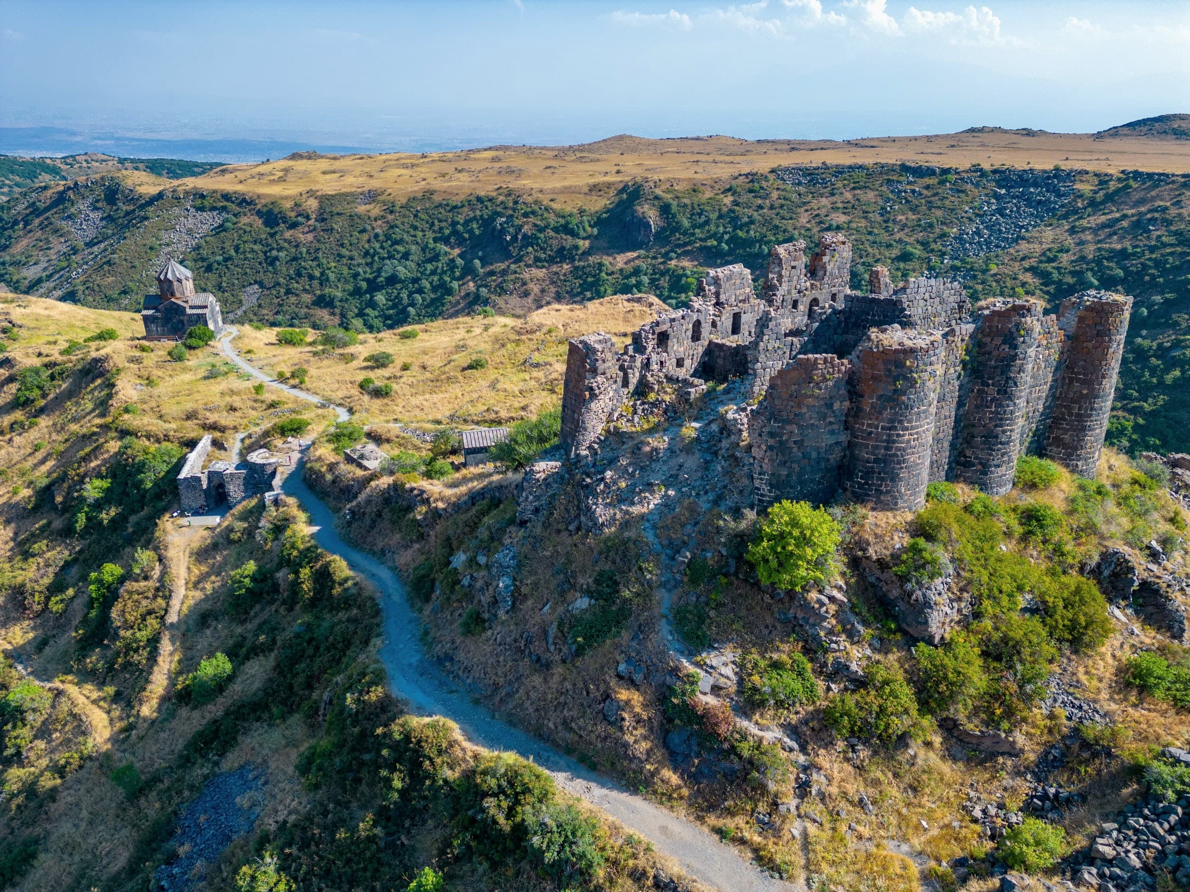 Amberd’s basalt towers on their spur, the church of Vahramashen along the path, the slope of Aragats falling away to the plain