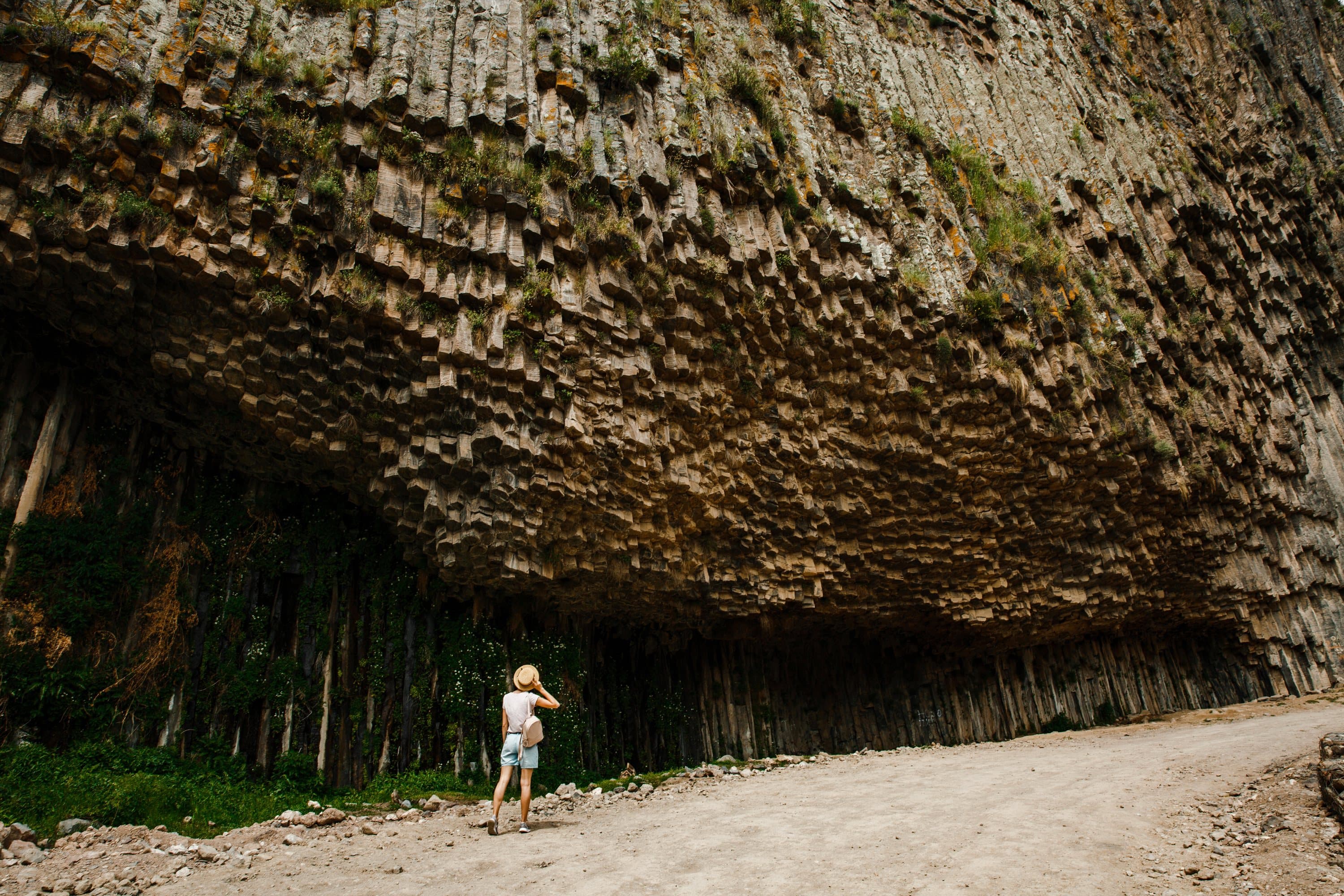 A traveller on the gorge path under an overhang of basalt columns at the Symphony of Stones.