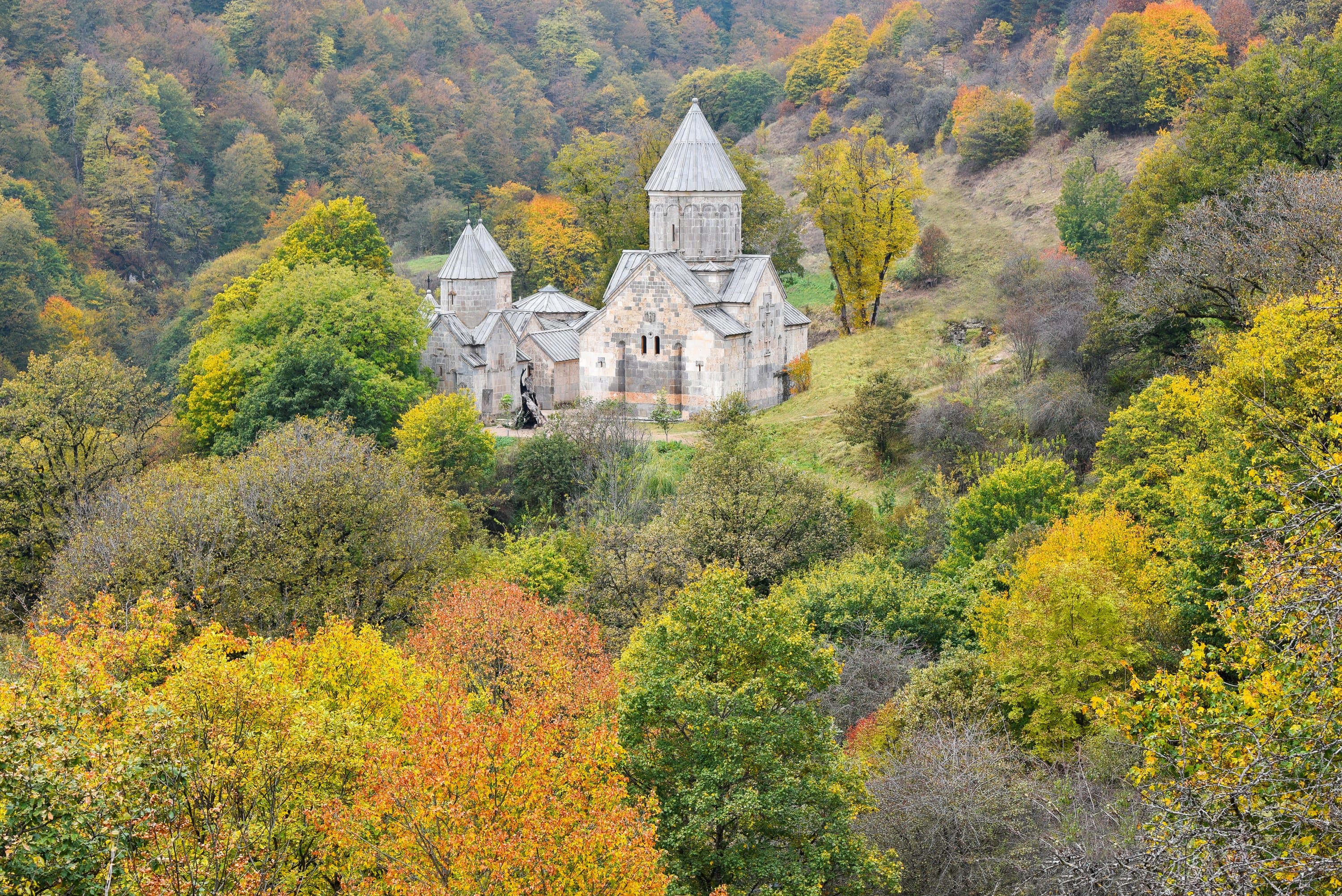 Haghartsin’s grey stone churches in a clearing of autumn forest