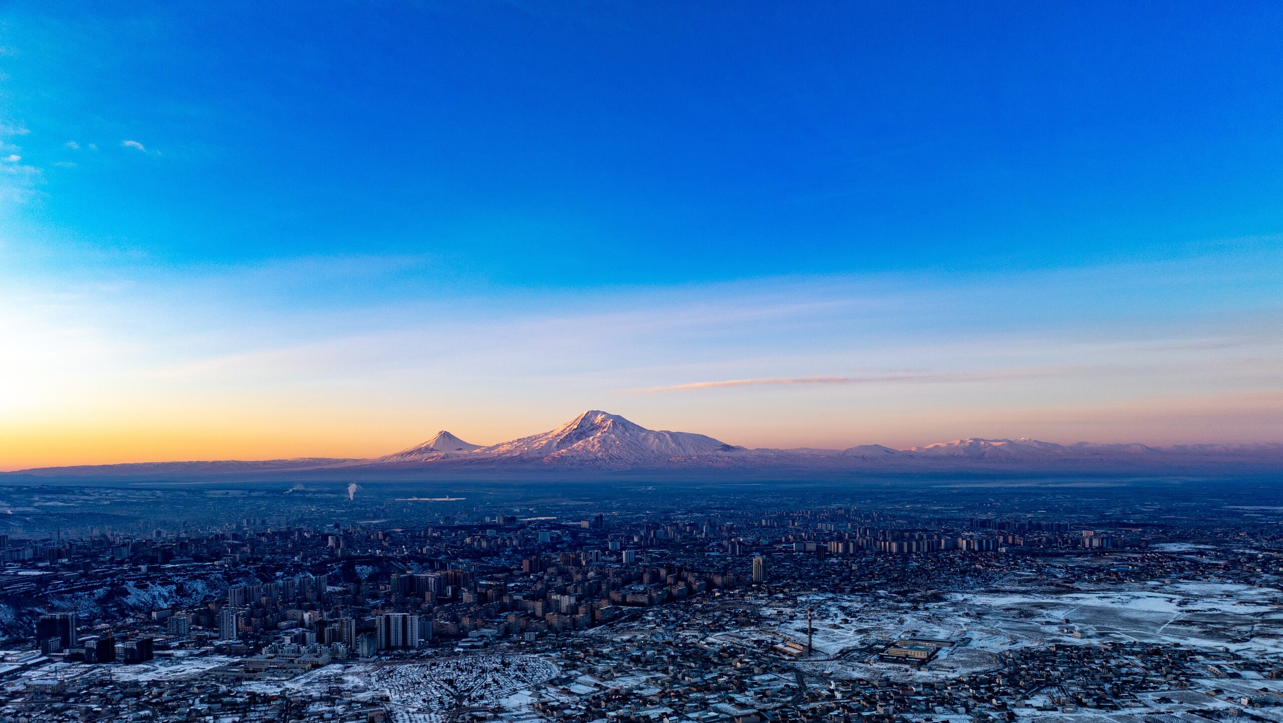 Yerevan under snow at first light, with the two snow-covered peaks of Ararat across the plain