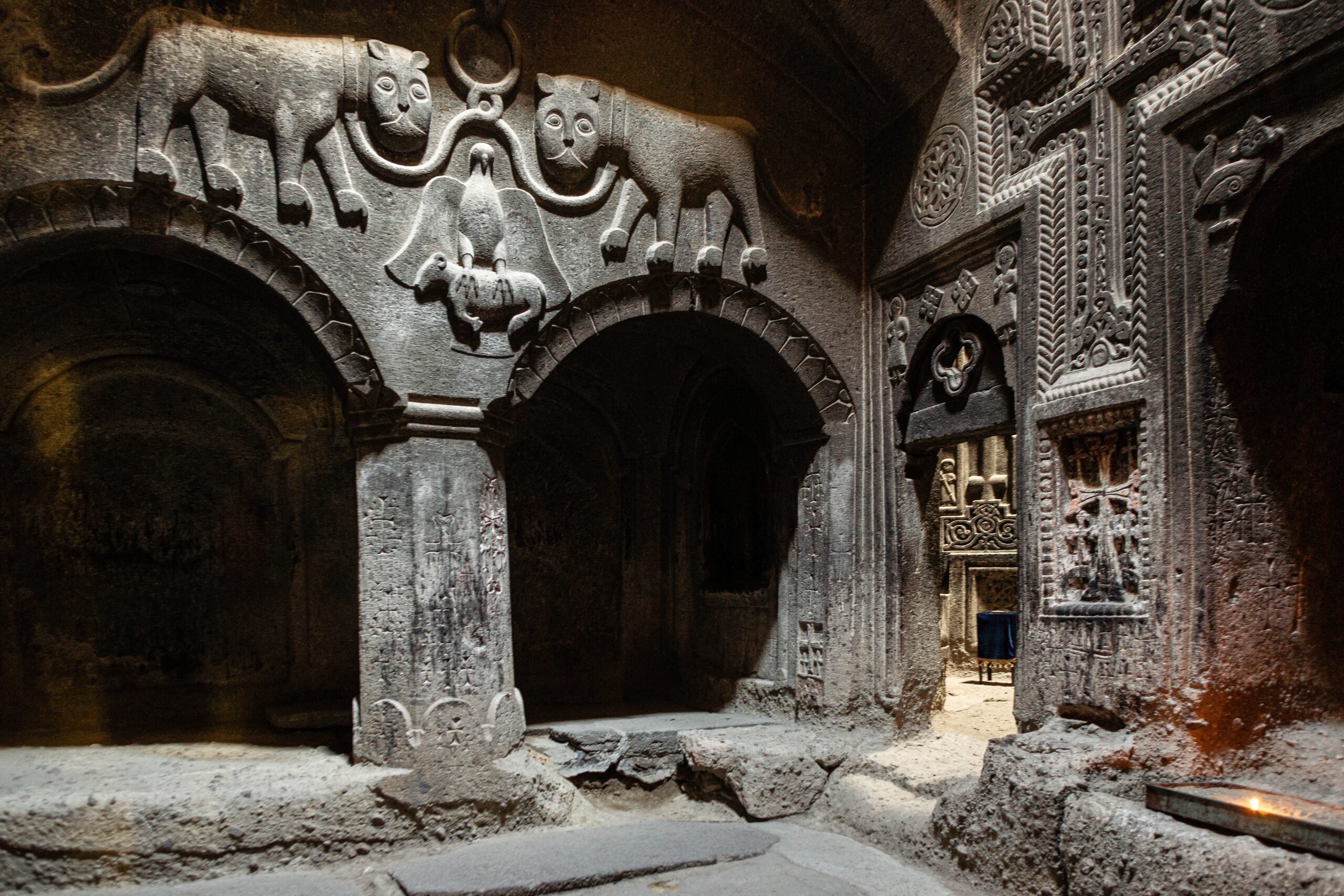 Inside Geghard, lit through the carved arches
